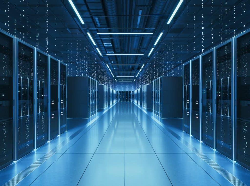 A long, futuristic server room with rows of dark server racks illuminated by blue light and falling data.